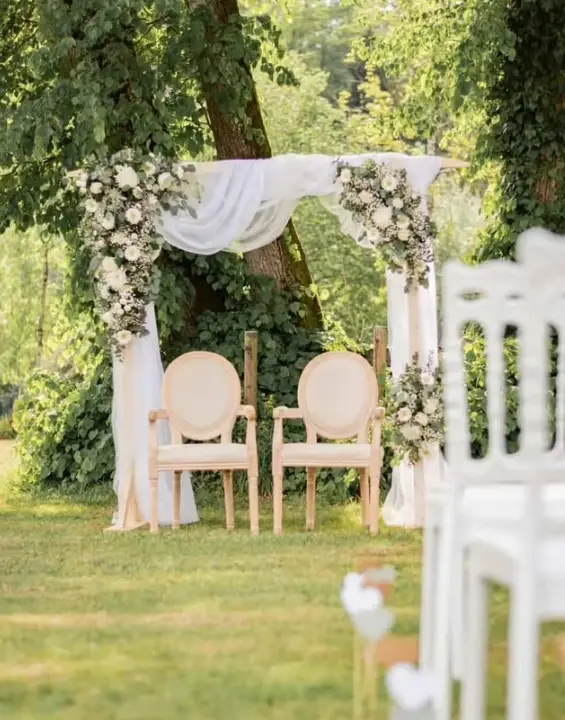 Arche de cérémonie laïque drapée de voilage blanc et fleurie de roses blanches, décorée par Mily Fleurs